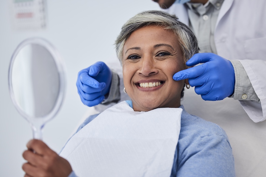 woman smiling in dental chair after cosmetic treatment, cosmetic dental treatment